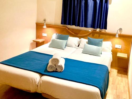 a bedroom with a large bed with towels on it at Apartamentos Petit Blau in Paguera