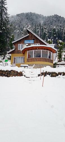 a house in the snow in front at Bente's Lodge in Pahalgām