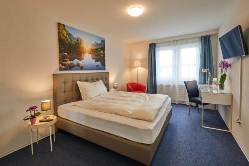 a hotel room with a large bed and a desk at Hotel Ambassador in Solothurn