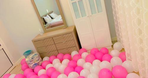 a pile of pink and white balloons in front of a mirror at شاليه دانة بحر in Yanbu