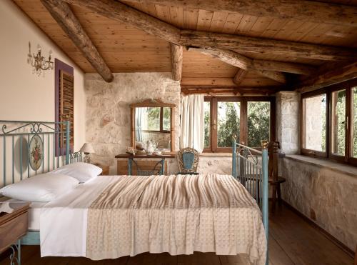 a bedroom with a bed in a room with wooden ceilings at Vafias Villa in Lithakia