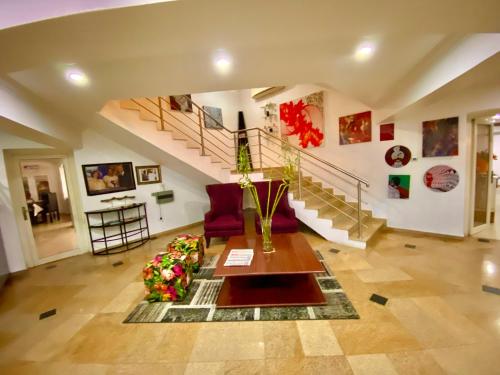 a living room with a couch and a table and stairs at Angel Hotel in Lagos