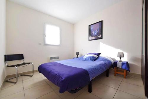 une chambre avec un grand lit avec une couverture violette dans l'établissement Maison de charme à Marsillargues avec jardin clos, à Marsillargues