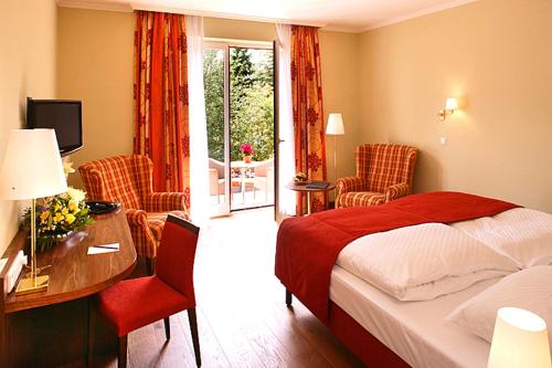 a hotel room with a bed and a desk and chairs at Ringhotel Warnemünder Hof in Warnemünde
