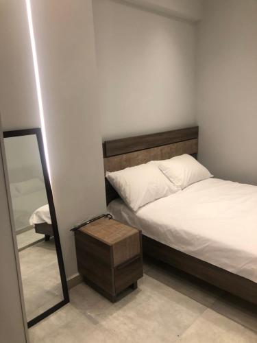 um pequeno quarto com uma cama e um espelho em LUXURY VASKO SUITES 2 em Tessalônica