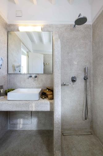 a bathroom with a sink and a mirror at Pelican Bay Hotel in Platis Yialos Mykonos