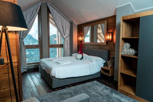sypialnia z łóżkiem w pokoju z oknami w obiekcie Chalet Everest - Luxury Apartments w mieście Prato Nevoso