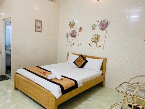 um quarto com uma cama com flores na parede em An San Hotel em Dĩ An
