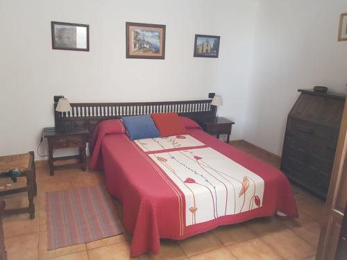 - une chambre avec un lit doté d'une couverture rouge et bleue dans l'établissement Casas Rurales Los Manantiales, à El Cercado