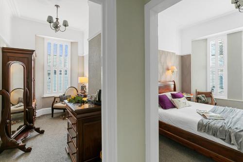1 dormitorio con cama, escritorio y silla en Southbank TOWN HOUSE, en Torquay
