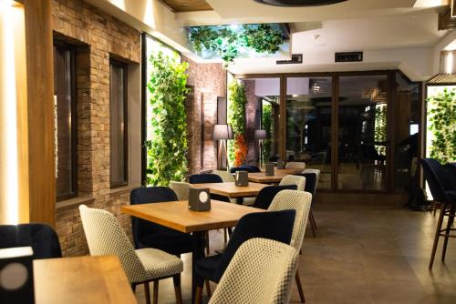 a restaurant with wooden tables and chairs and plants at Hotel City IN in Kochani
