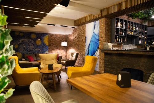 un restaurant avec des chaises jaunes et un bar dans l'établissement Hotel City IN, à Kotchani
