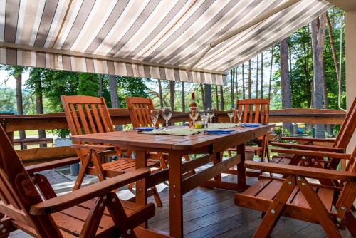 una mesa de madera y sillas en un patio en Bendegúz Vendégház, en Orfű