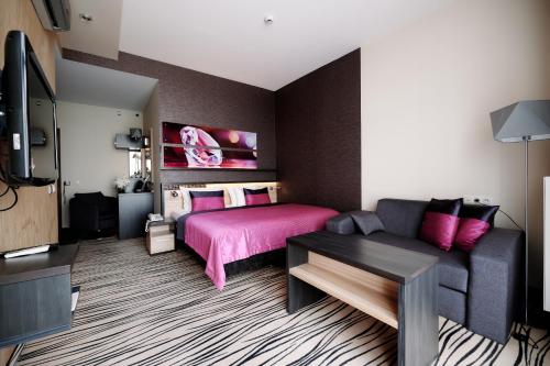 a living room with a bed and a couch at Blue Diamond Hotel Active SPA in Rzeszów