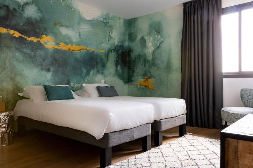 a bedroom with a large bed with a painting on the wall at Résidence Casarina in Bonifacio