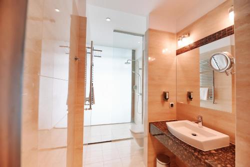 a bathroom with a sink and a shower at Blue Diamond Hotel Active SPA in Rzeszów
