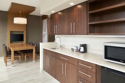 a kitchen with wooden cabinets and a table with a microwave at Hyatt Place Evansville in Evansville
