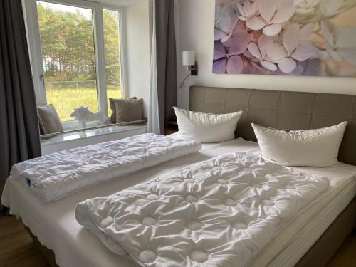 2 camas en una habitación con ventana grande en Haus Arkona - Meeresrausch, en Binz