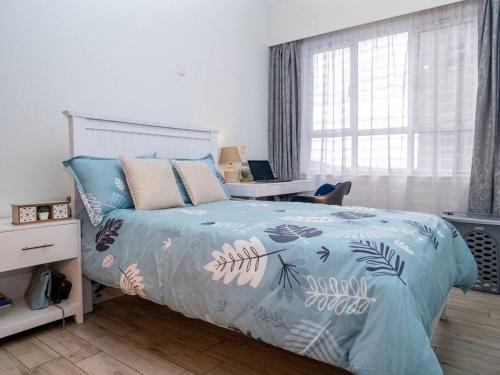 a bedroom with a bed with a blue comforter at Nyumba Nzuri 2 bedroom apartment central of NBO in Nairobi