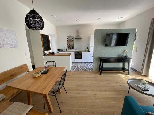 ein Wohnzimmer mit einem Tisch und einer Küche in der Unterkunft Ferienwohnung Weingut Höllerer in Engabrunn