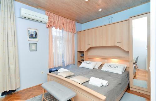 sypialnia z dużym łóżkiem z drewnianym zagłówkiem w obiekcie Apartments Jasna 1128 w Fažanie