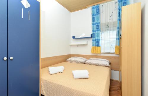 um pequeno quarto com uma cama com duas toalhas em Apartments Jasna 1128 em Fažana