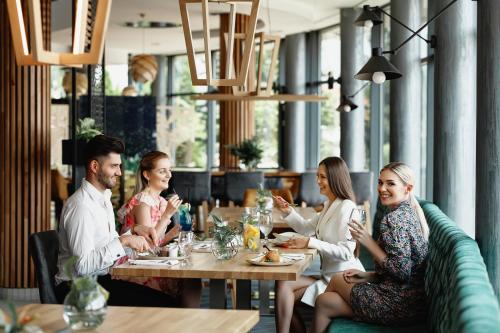 a group of people sitting at a table in a restaurant at Blue Diamond Hotel Active SPA in Rzeszów