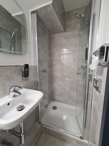 y baño con ducha, lavamanos y ducha. en Altan Hotel en Hamburgo
