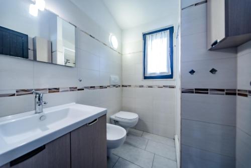 モンテ・ナイにあるCasa Le Tuieの白いバスルーム(洗面台、トイレ付)