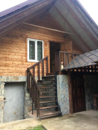 a wooden house with stairs and a window at Шепіт лісу in Sheshory