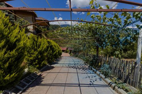 a walkway in a garden with a wooden fence at Vaio Resort in Keda in Keda