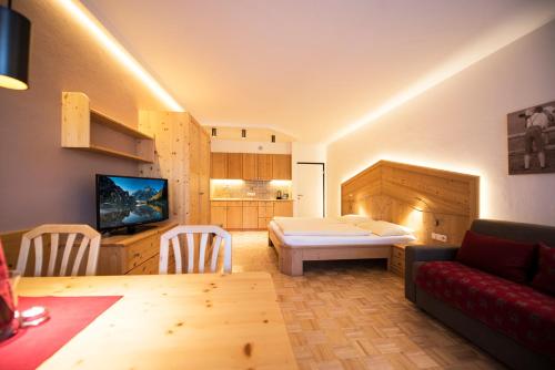 een woonkamer met een bank en een tafel in een kamer bij Apartment Lilli mit Garagenstellplatz in Bressanone