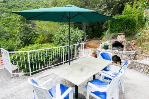 a table and chairs with an umbrella on a patio at Apartments Laura Mljet in Sobra