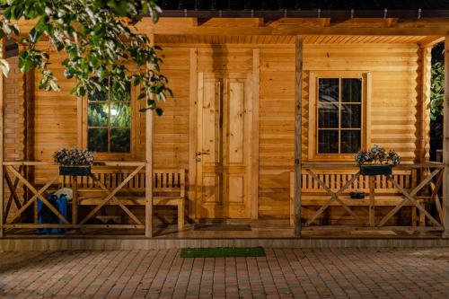 a wooden cabin with two benches and windows at Vaio Resort in Keda in Keda