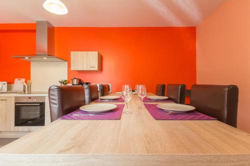 d'une salle à manger avec une table, des chaises et des murs orange. dans l'établissement Chez Germaine, à Saint-Romain