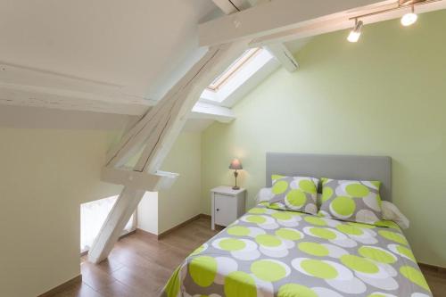 1 dormitorio con 1 cama con edredón verde y blanco en Chez Germaine, en Saint-Romain