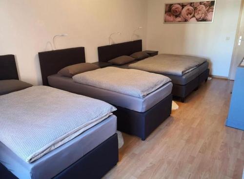 three beds in a room with wooden floors at Ferienwohnung in Neustadt-Glewe