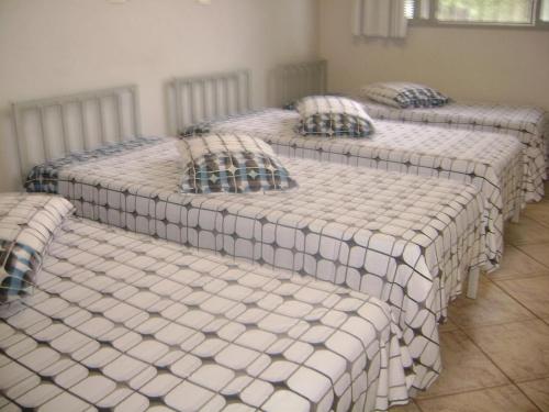 a group of four beds in a room at Hotel Arbom in Mogi-Guaçu
