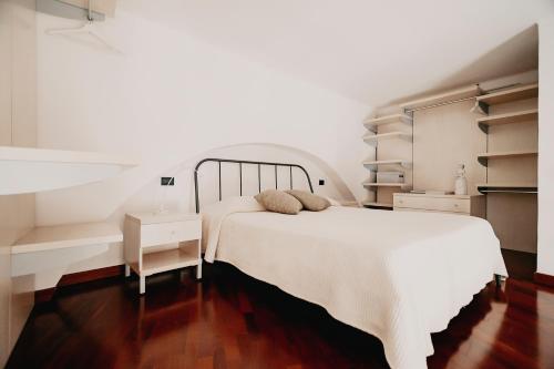 1 dormitorio con cama blanca, escritorio y estanterías en CASA FISCARDI, en Bari