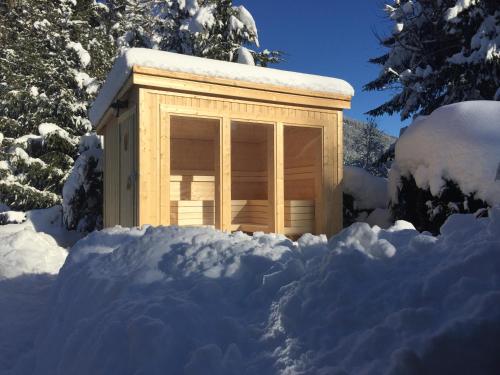 a wooden building in a pile of snow at Villa Ruah in Weissensee