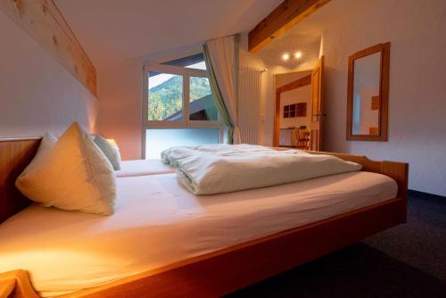 Schlafzimmer mit einem großen Bett und einem Fenster in der Unterkunft Haus im Winkl in Bad Hindelang