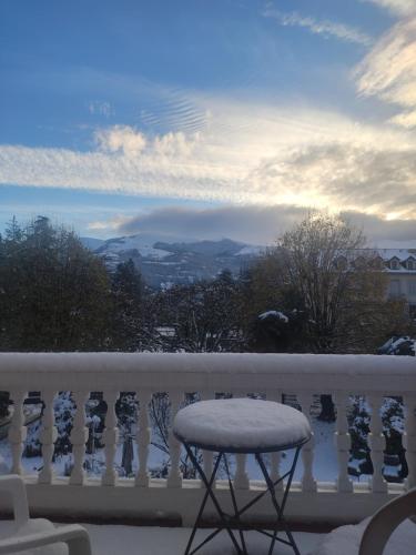 uno sgabello su un balcone con neve di Studio avec terrasse vue Tourmalet dans Villa historique "Victoria" ad Argelès-Gazost