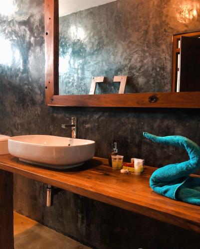 a bathroom counter with a sink and a mirror at White Sands in Paje