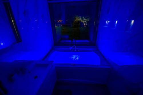 a blue room with a tub and a window at Villa Nera - Etwa in Mostar