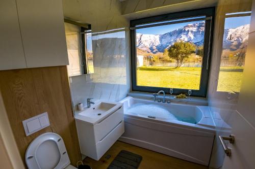 ein Bad mit einer Badewanne, einem Waschbecken und einem Fenster in der Unterkunft Villa Nera - Etwa in Mostar