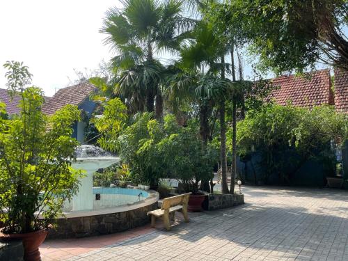 a garden with a bench and a swimming pool at Song Tra Hotel in Xóm Phước Mỹ