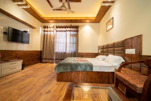 a bedroom with a bed and a television in it at Mathan View Homestay - 3min Drive to Kullu-Manali Airport in Shamshi