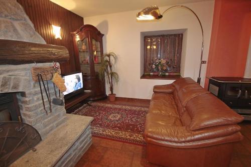 a living room with a leather couch and a fireplace at Armona in Susa