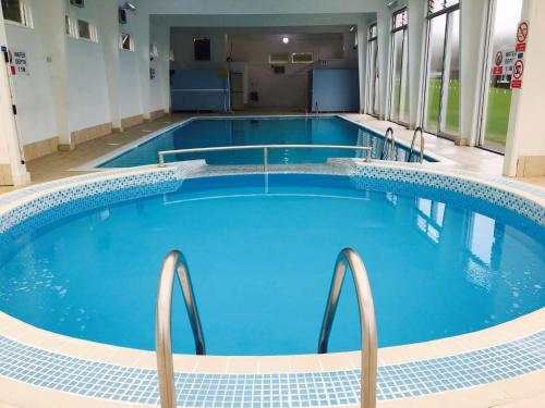 uma grande piscina num edifício hospitalar com água azul em Glade Lodge- North Devon Coast, Bideford Bay Caravan Park em Bideford