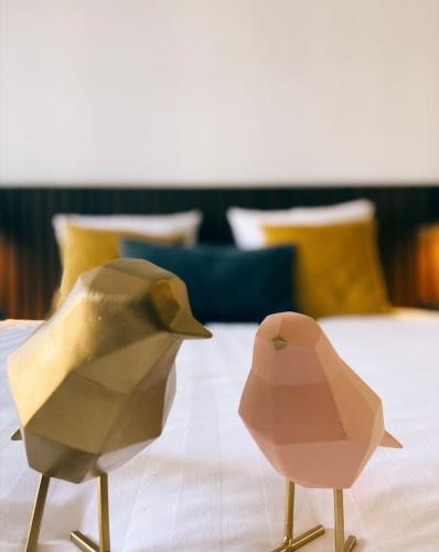 two paper birds sitting on top of a bed at Alex Maastricht in Maastricht